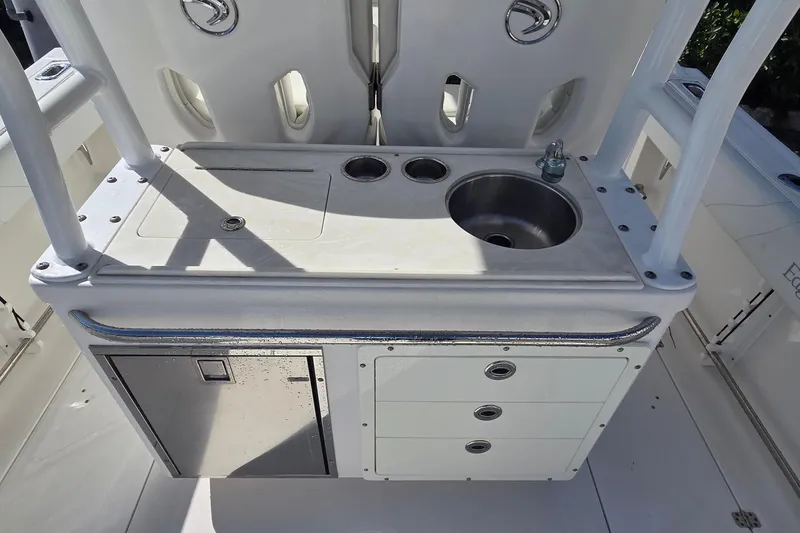 Slide: The Image of Edgewater 280CC 2018 boat console with sink, storage drawers, and stainless steel fixtures. - 12
