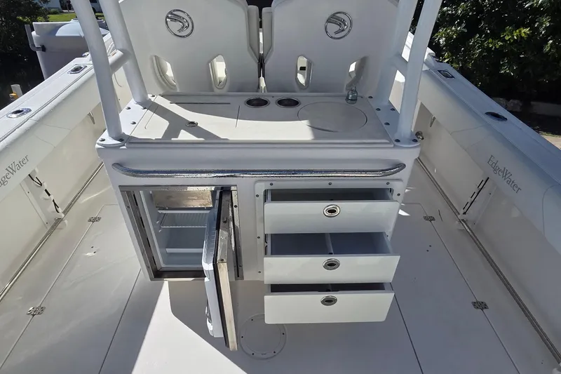 Slide: The Image of 2018 Edgewater 280CC boat interior with open storage drawers and mini fridge. - 13