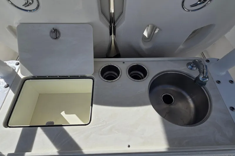 Slide: The Image of 2018 Edgewater 280CC boat sink and storage compartment on deck. - 14