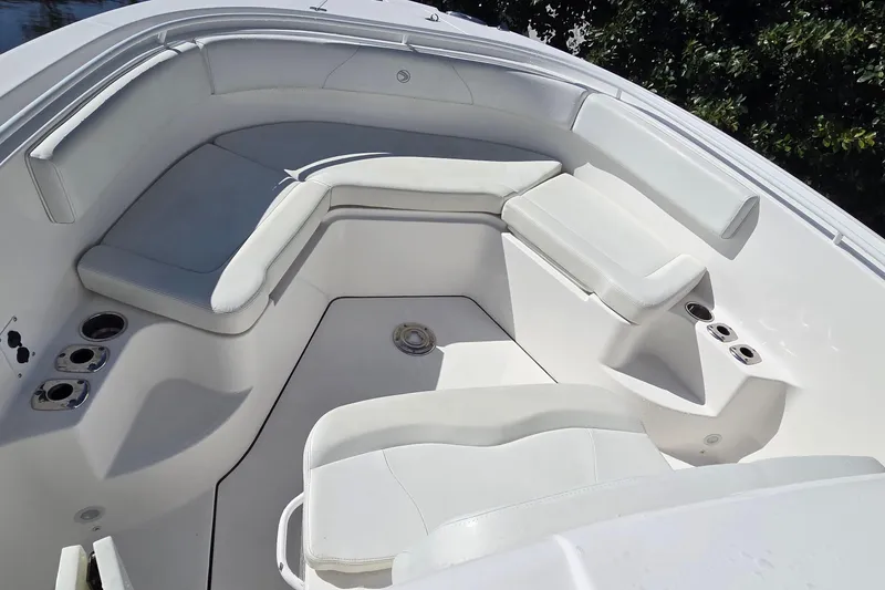 Slide: The Image of 2018 Edgewater 280CC boat interior with white cushioned seating and cup holders. - 23