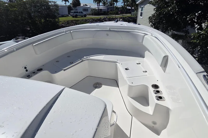 Slide: The Image of 2018 Edgewater 280CC boat interior with sleek white seating and storage compartments. - 7