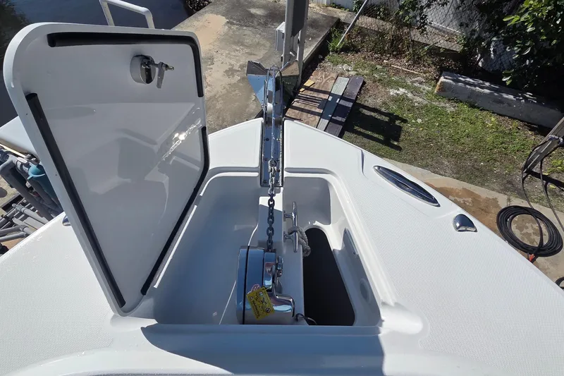 Slide: The Image of Open anchor compartment on 2018 Edgewater 280CC boat, showcasing chain and mechanism. - 9