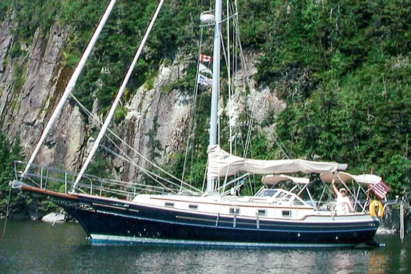 The Image of Sailboat Gozzard 37A, 1999 model, anchored near rocky, forested shoreline. - 1