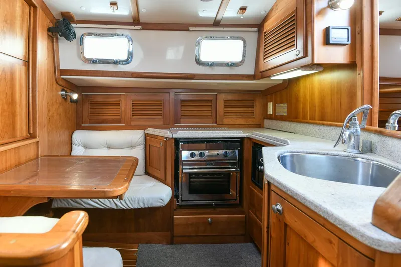 Slide: The Image of Interior of 1999 Gozzard 37A yacht with wooden cabinetry and compact kitchen area. - 25