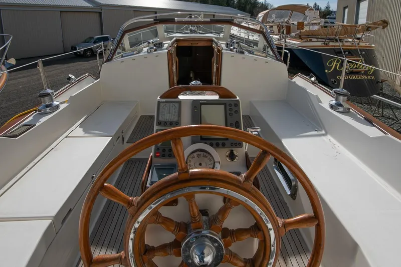 Slide: The Image of Cockpit view of 1999 Gozzard 37A sailboat with wooden steering wheel and navigation instruments. - 5