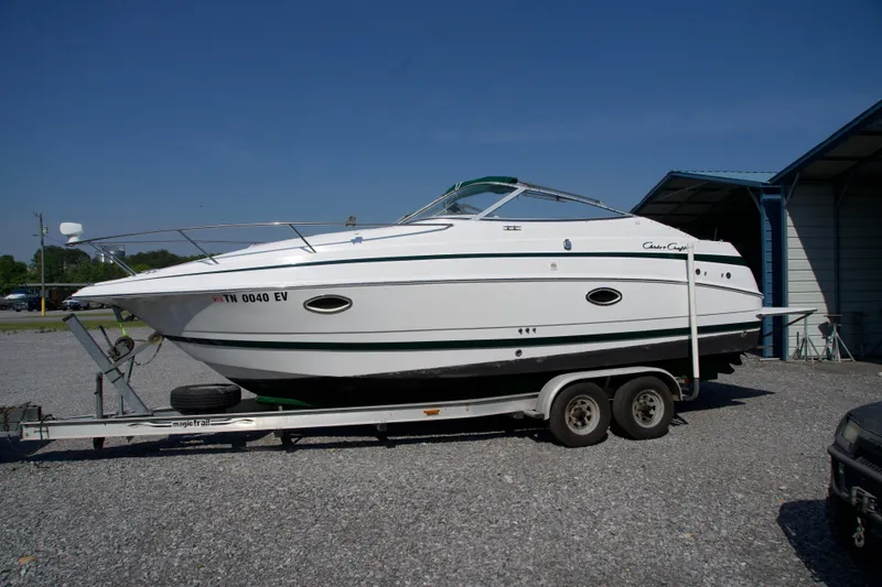 The Image of 2000 Chris-Craft boat on trailer, parked outdoors under clear blue sky. - 0