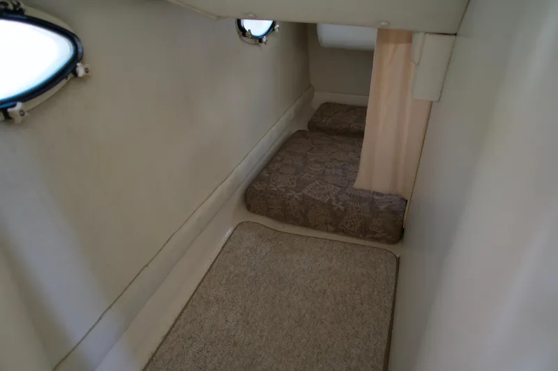 Slide: The Image of Interior cabin of a 2000 Chris-Craft boat with cushions and portholes. - 11