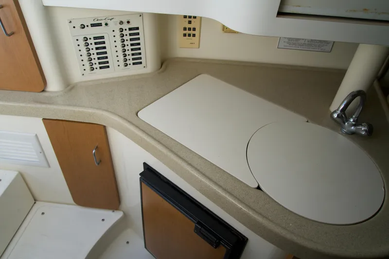 Slide: The Image of Chris-Craft 2000 boat interior with control panel, sink, and storage cabinets. - 13