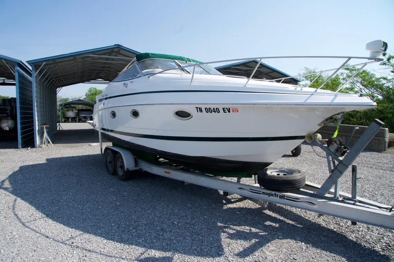 Slide: The Image of 2000 Chris-Craft boat on trailer, parked in a covered storage area. - 2