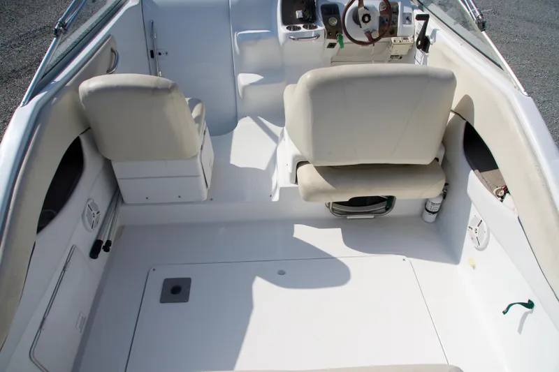 Slide: The Image of Interior of a 2000 Chris-Craft boat featuring white seating and steering area. - 4