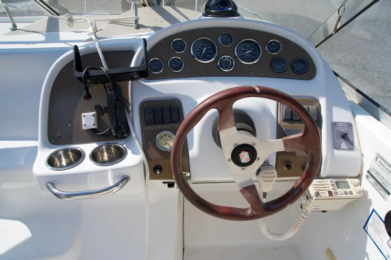 Slide: The Image of Steering console of a 2000 Chris-Craft boat with gauges and wooden wheel. - 5