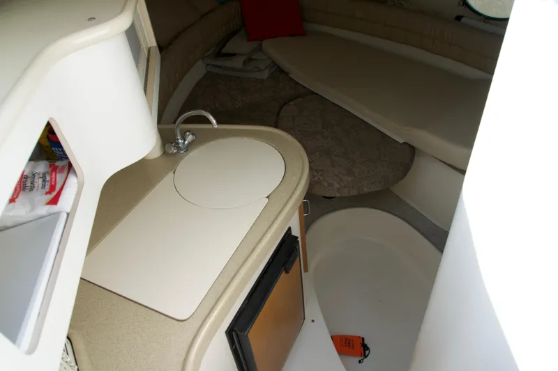 Slide: The Image of Interior of a 2000 Chris-Craft boat featuring a compact kitchenette and seating area. - 9
