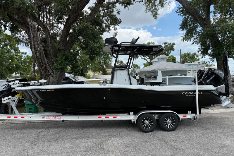 Slide: The Image of 2025 Caymas 281 HB boat on trailer, parked outdoors under trees. - 10
