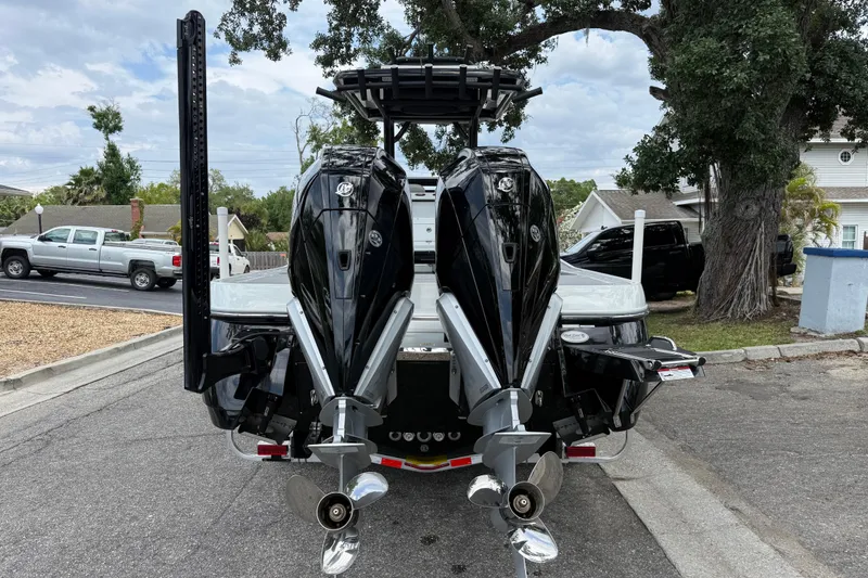 Slide: The Image of 2025 Caymas 281 HB boat with dual outboard motors, parked on a residential street. - 11