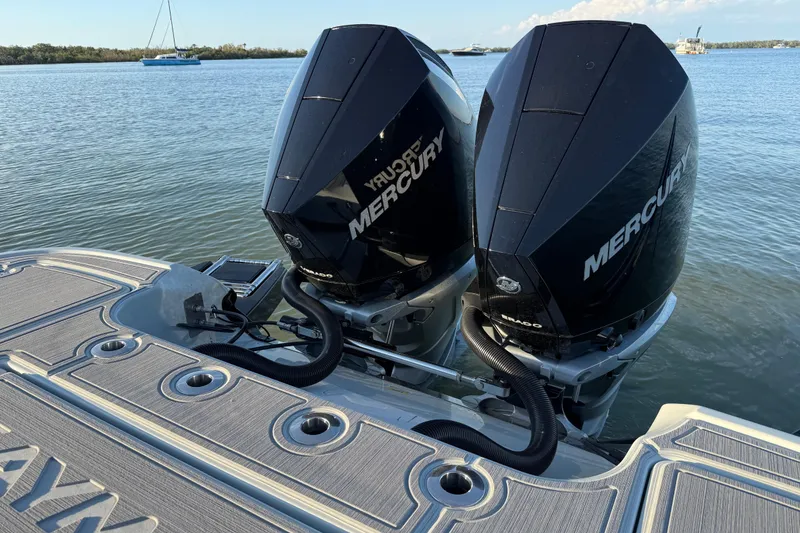 Slide: The Image of 2025 Caymas 281 HB boat with dual Mercury outboard engines on a calm lake. - 18