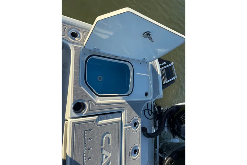 Slide: The Image of 2025 Caymas 281 HB boat deck with open storage compartment and visible engine. - 22
