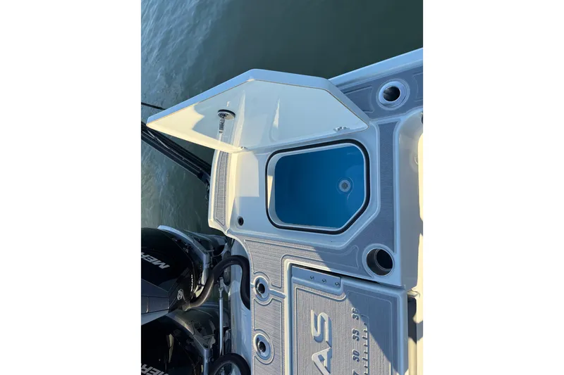Slide: The Image of 2025 Caymas 281 HB boat deck with open storage compartment and visible engine. - 23