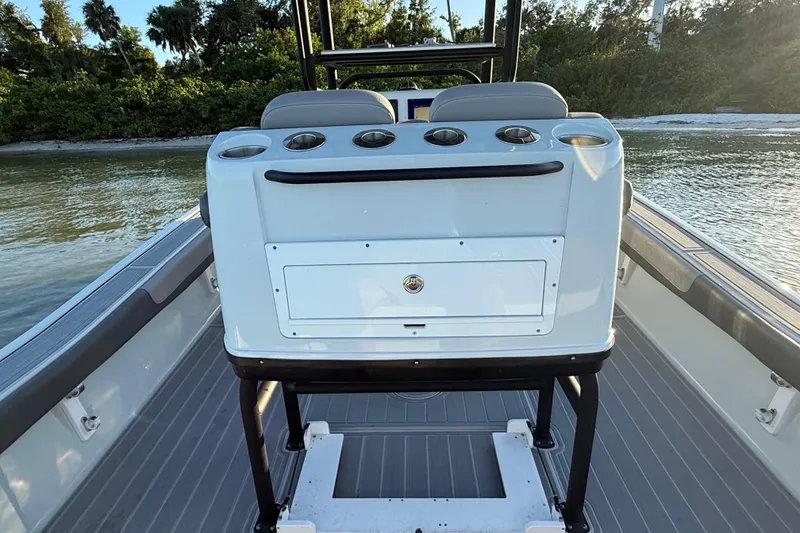 Slide: The Image of 2025 Caymas 281 HB boat interior with seating and storage, surrounded by water and greenery. - 25