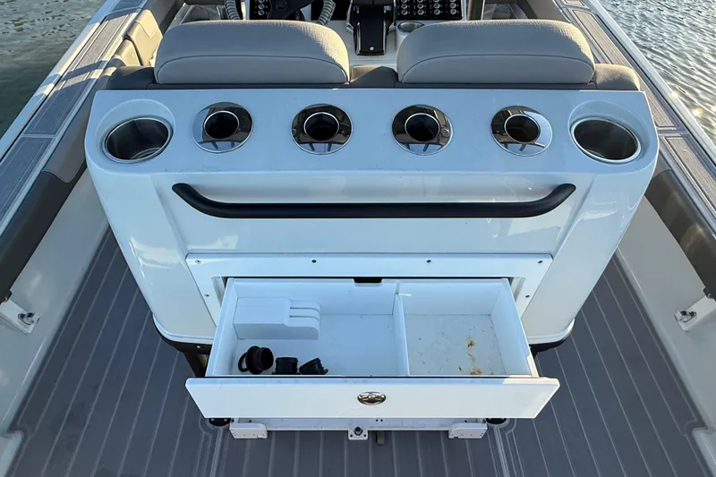 Slide: The Image of 2025 Caymas 281 HB boat console with cup holders and open storage drawer. - 26