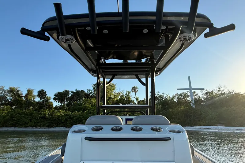 Slide: The Image of 2025 Caymas 281 HB boat with T-top, docked near lush greenery and a cross. - 27