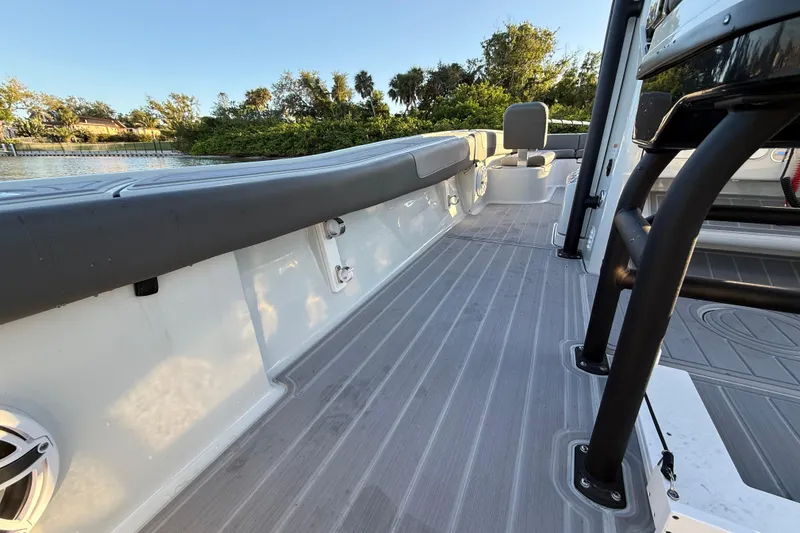 Slide: The Image of 2025 Caymas 281 HB boat deck with seating, near water and greenery. - 28
