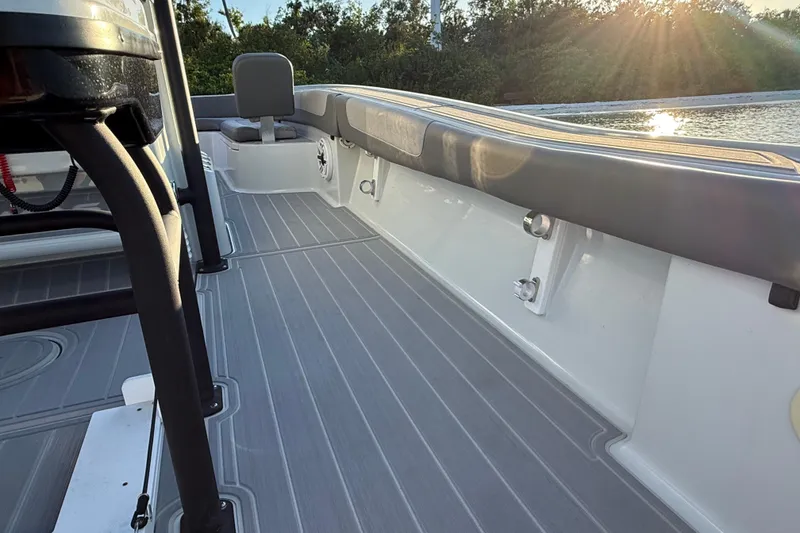 Slide: The Image of 2025 Caymas 281 HB boat deck with seating, sunlit water, and lush greenery. - 29