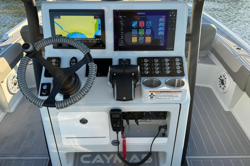 Slide: The Image of 2025 Caymas 281 HB boat dashboard with steering wheel, navigation screens, and control panel. - 33