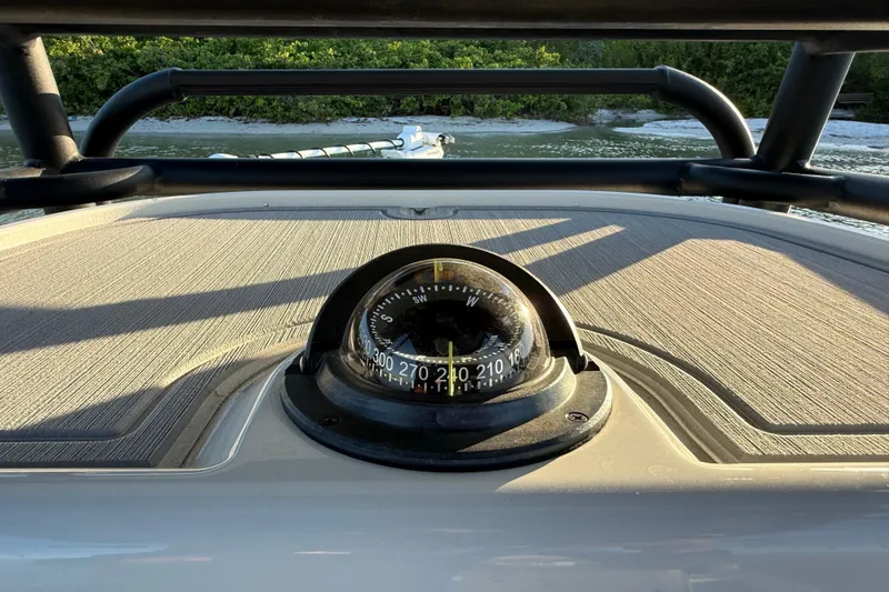Slide: The Image of Compass on 2025 Caymas 281 HB boat, with scenic shoreline background. - 35