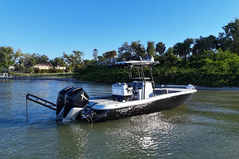 Slide: The Image of 2025 Caymas 281 HB boat on calm water, surrounded by lush greenery. - 4