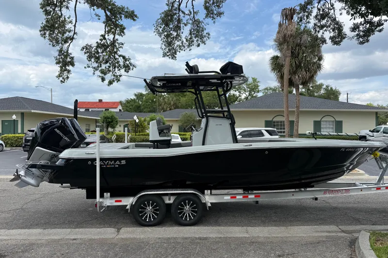 Slide: The Image of 2025 Caymas 281 HB boat on trailer, parked outdoors under cloudy sky. - 9
