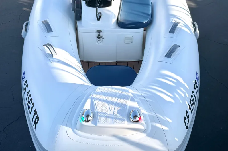 Slide: The Image of 2018 Brig Falcon 360 inflatable boat with blue seating and registration number visible. - 12