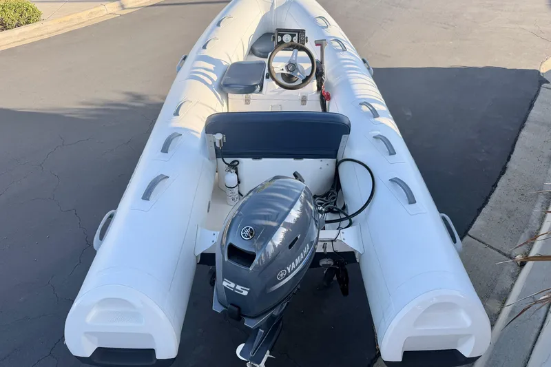 Slide: The Image of 2018 Brig Falcon 360 inflatable boat with Yamaha 25 outboard motor on pavement. - 17