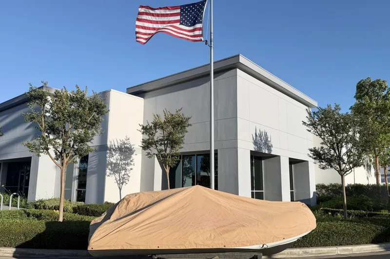 Slide: The Image of Covered 2018 Brig Falcon 360 boat outside modern building with American flag. - 22
