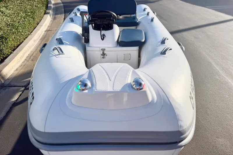 Slide: The Image of 2018 Brig Falcon 360 inflatable boat on pavement, showcasing sleek design and seating. - 6