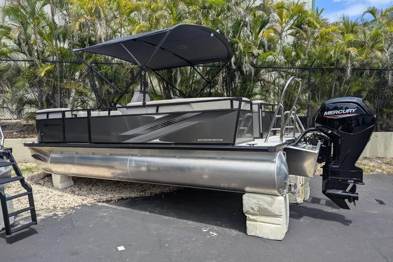 Slide: The Image of Dockside 22DQ2.75 pontoon boat, 2026 model, with Mercury outboard motor, parked outdoors. - 10