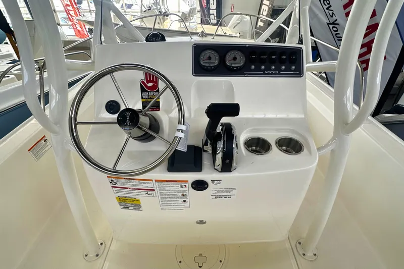 Slide: The Image of 2026 Boston Whaler 190 Montauk boat console with steering wheel and controls. - 15