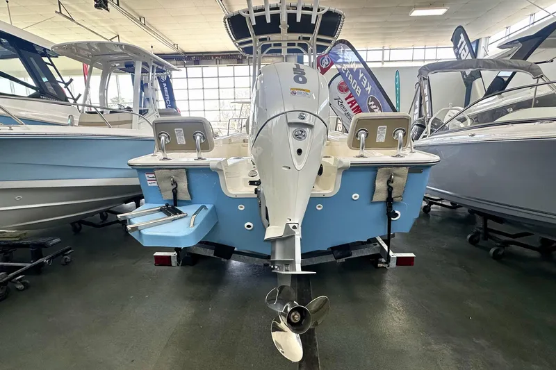 Slide: The Image of 2026 Boston Whaler 190 Montauk boat displayed in showroom, rear view with motor. - 2