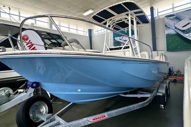 Slide: The Image of 2026 Boston Whaler 190 Montauk boat in showroom, displayed on a trailer. - 23