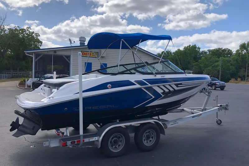 Slide: The Image of 2015 Regal 2000 ESX Bowrider on trailer, blue and white design, parked outdoors. - 4