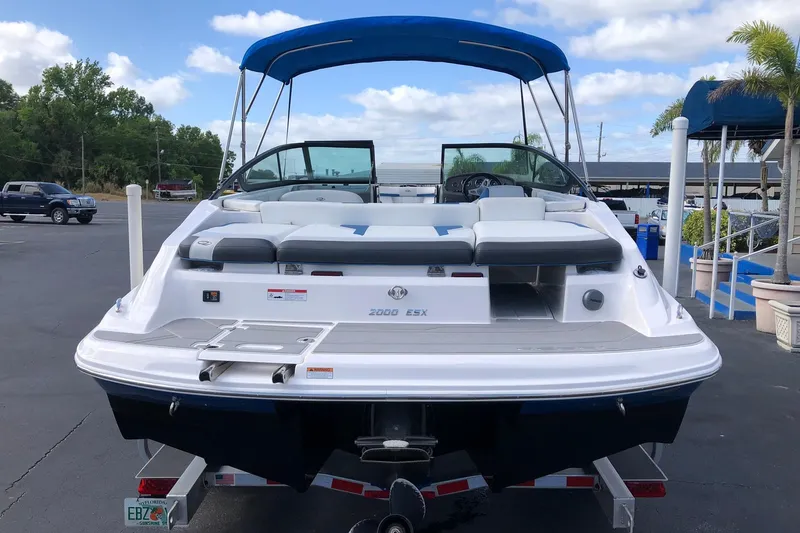 Slide: The Image of 2015 Regal 2000 ESX Bowrider with blue canopy, parked on trailer. - 5