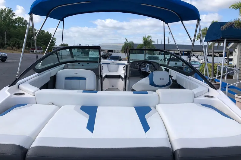 Slide: The Image of 2015 Regal 2000 ESX Bowrider with blue and white interior, docked under a blue canopy. - 6