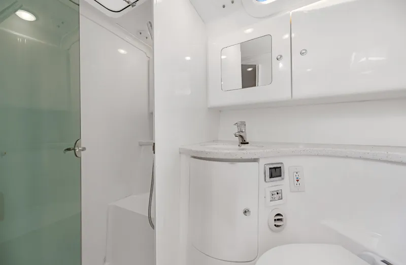 Slide: The Image of Modern bathroom in 2016 Intrepid 400 Cuddy boat with shower, sink, and storage cabinets. - 25