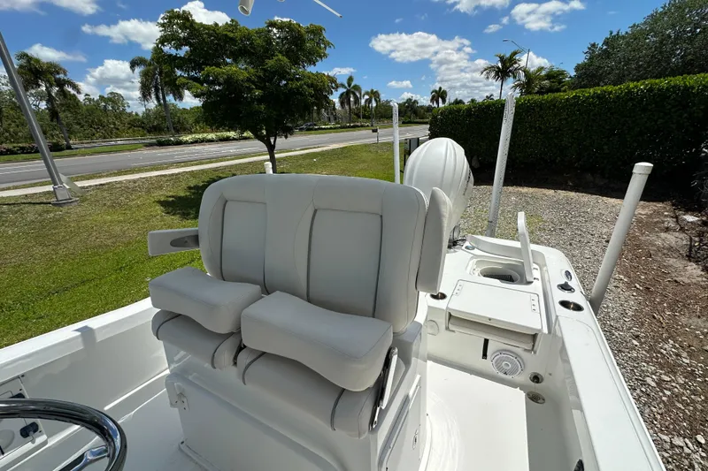Slide: The Image of 2023 Sea Hunt BX 25 BR boat with plush seating, parked outdoors under a sunny sky. - 15