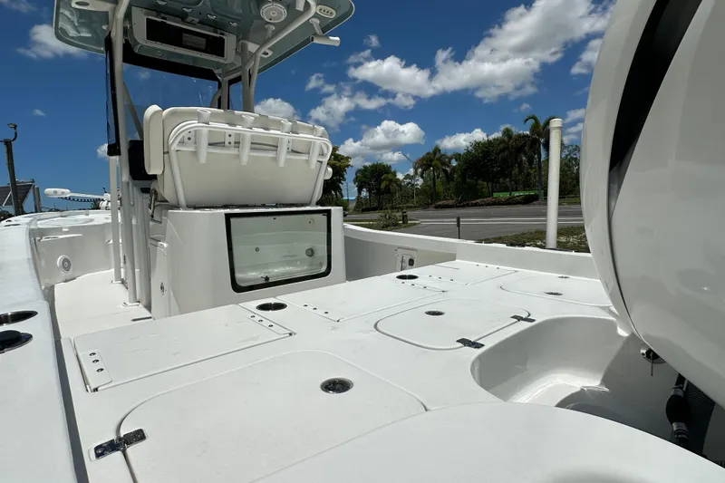 Slide: The Image of 2023 Sea Hunt BX 25 BR boat interior with seating and storage, under a clear blue sky. - 8