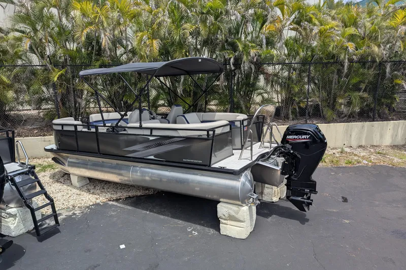 Slide: The Image of 2026 Dockside 22DQ2.75 pontoon boat with Mercury outboard motor, parked outdoors. - 10