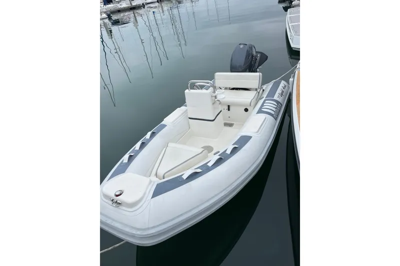 Slide: The Image of Small inflatable boat docked, featuring a central console and outboard motor. - 38