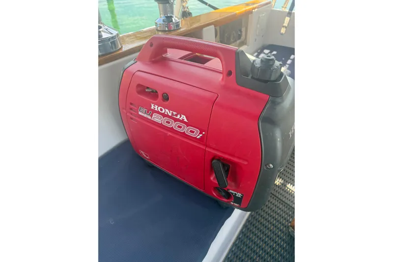 Slide: The Image of Red Honda EU2000i generator on a 1995 Island Packet 37 sailboat deck. - 10