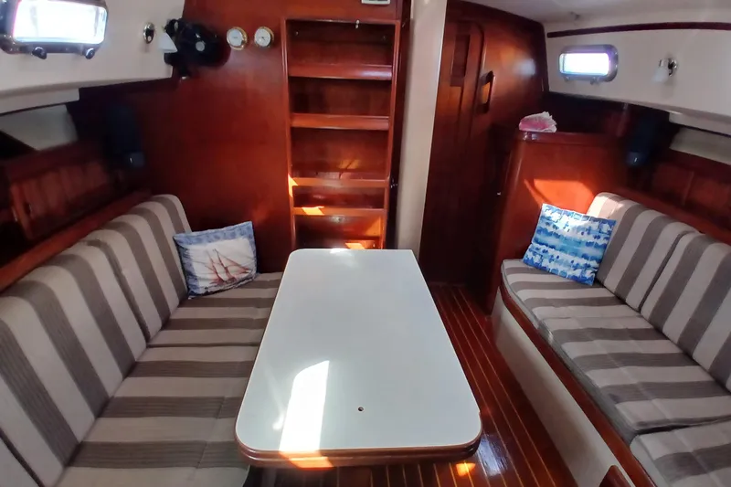 Slide: The Image of Interior of 1995 Island Packet 37 sailboat with striped seating and wooden finishes. - 15