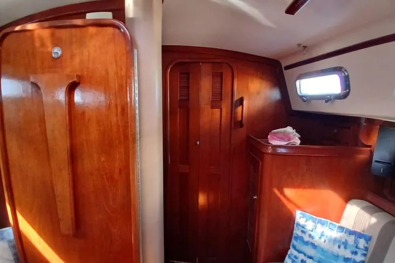 Slide: The Image of Interior of 1995 Island Packet 37 sailboat with wooden cabinetry and porthole window. - 18