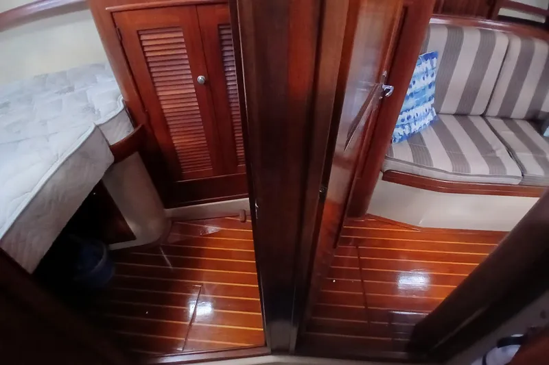 Slide: The Image of Interior of a 1995 Island Packet 37 sailboat with wood flooring and cozy seating. - 26
